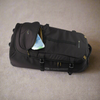 Black suitcase with open top compartment on a beige carpet