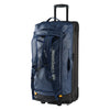 A blue Caribee Odyssey Hybrid 100L wheel travel bag with concealable shoulder straps exposed. Features telescopic handle, top and side carry options, and all-terrain wheels.