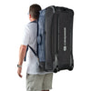 Caribee Odyssey Hybrid travel bag shown with backpack straps and being worn by a male traveler