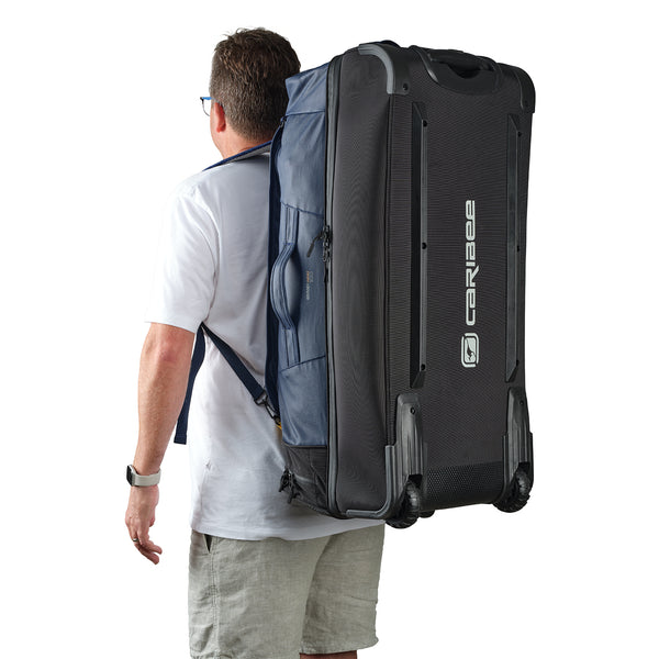 Caribee Odyssey Hybrid travel bag shown with backpack straps and being worn by a male traveler
