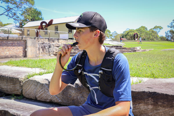 Hydration backpack in use. runner drinking from hydration running vest