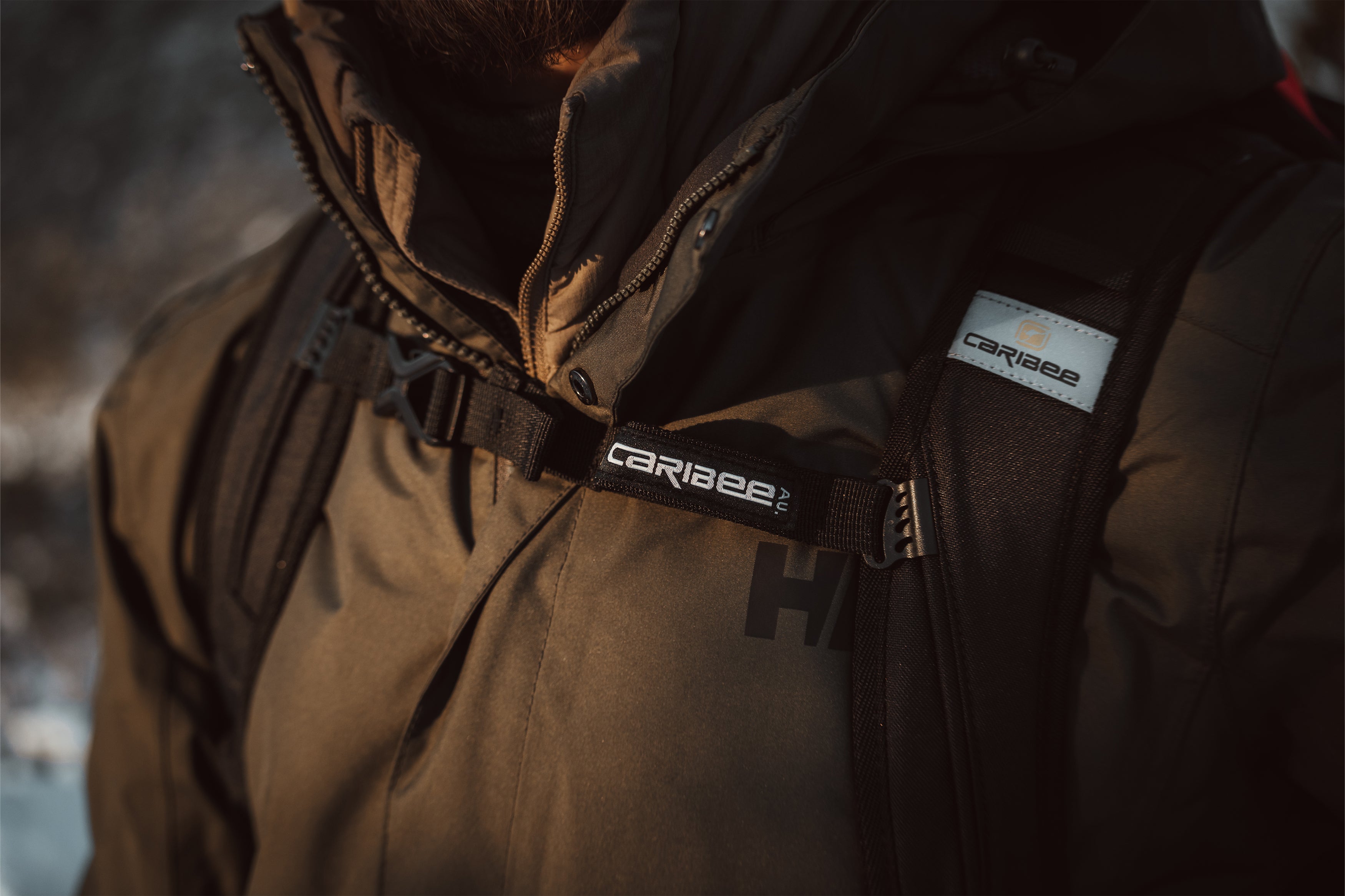 Brown jacket with Caribee logo on a blurred background