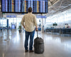 Man with a Caribee Adventure 40 standing in an airport terminal looking at the departure board.